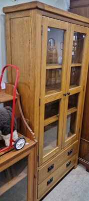 Lot 675 - A modern oak cabinet with two glazed cupboard...