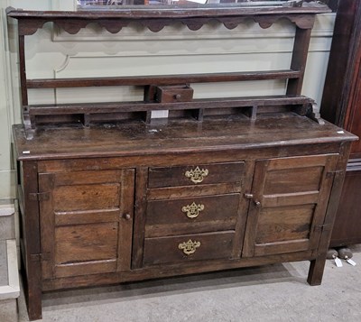 Lot 680 - A George III oak dresser, the upper section...