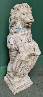 Lot 784 - A pair of composite stone garden lions, each...