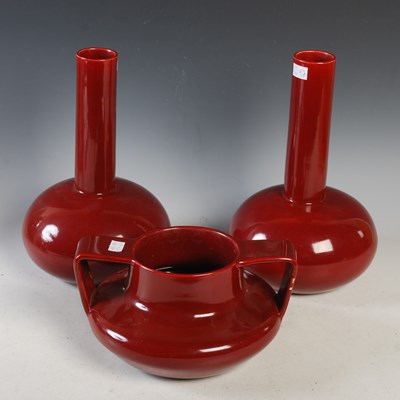 Lot 418 - A pair of red glazed bottle-neck vases, both...