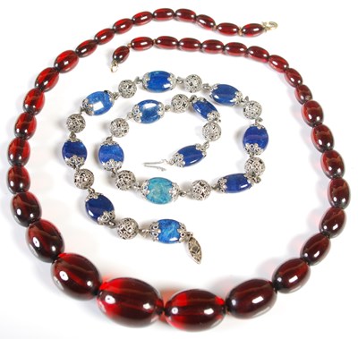 Lot 51 - A red amber type graduated bead necklace,...