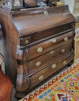 Lot 819 - An 18th century oak bombe bureau the...