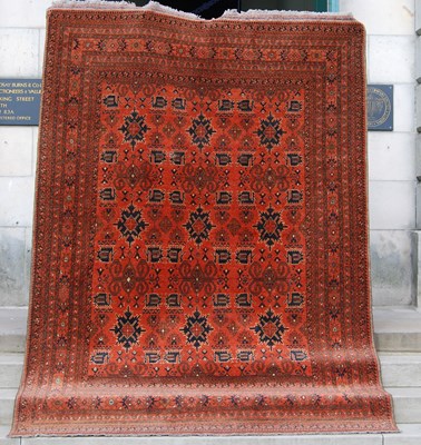 Lot 903 - A large Persian rug, the madder ground...