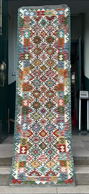 Lot 913 - A 20th century Chobi Kilim runner, worked in...