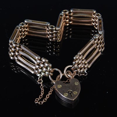 Lot 438 - A yellow metal gatelink bracelet, with heart...