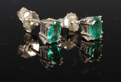 Lot 404 - A pair of 18ct white gold emerald and diamond...