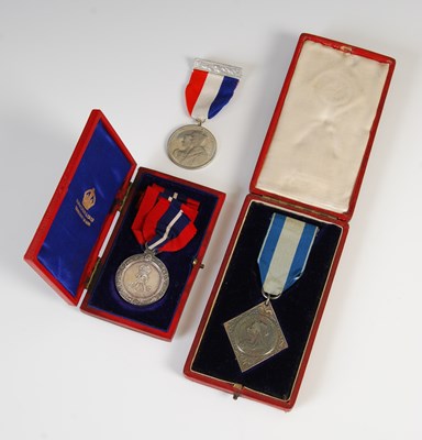 Lot 77 - A group of three medals to include red leather...