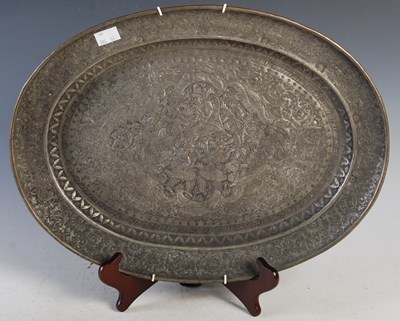 Lot 391 - A Persian silvered copper oval dish chased...