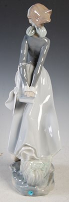 Lot 406 - A Lladro porcelain figure of a girl holding a...