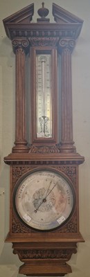 Lot 714 - A late 19th century oak aneroid barometer of...