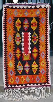 Lot 776 - A small kilim rug, the black ground centred...