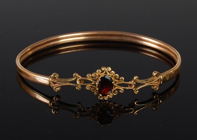 Lot 46 - A 9ct gold and garnet set oval bangle, gross...