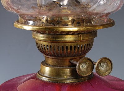 Lot 284 - A brass and ruby glass paraffin burning oil...