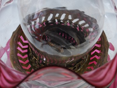 Lot 284 - A brass and ruby glass paraffin burning oil...