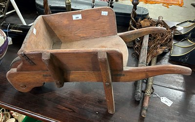 Lot 388 - A vintage wooden childs wheelbarrow with iron...