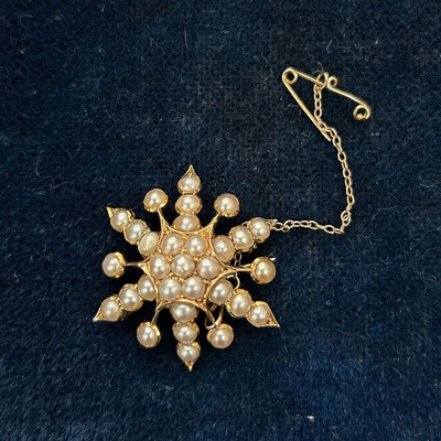 Lot 222 - A yellow metal and split pearl sunburst brooch,...