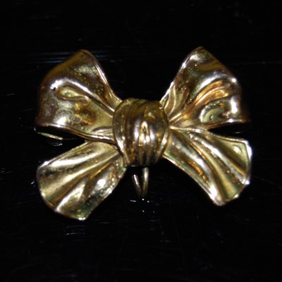 Lot 207C - A yellow metal brooch in the form of a bow,...