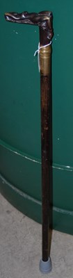 Lot 546 - An ebonised walking cane with brass handle of...