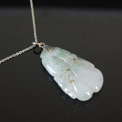 Lot 657 - A Chinese pale grey/green jade pendant, carved...