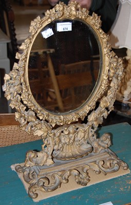 Lot 674 - A gilt dressing table mirror, the oval glass...