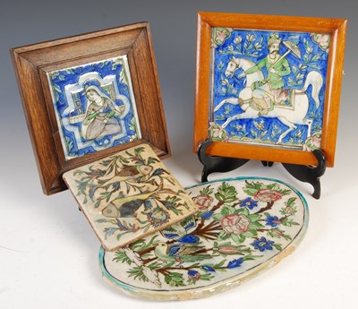 Lot 887 - A group of four Persian Qajar pottery tiles,...