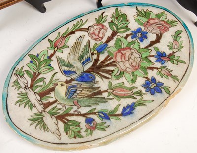 Lot 887 - A group of four Persian Qajar pottery tiles,...