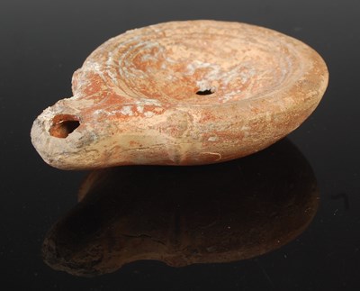 Lot 31 - A Roman pottery oil lamp, of typical form,...