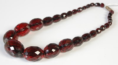 Lot 310 - A vintage red amber type faceted graduated...