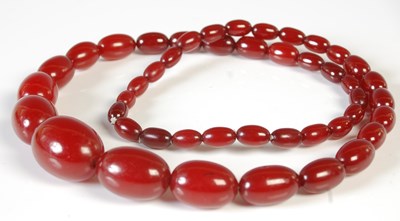 Lot 327 - A red amber type graduated bead necklace,...