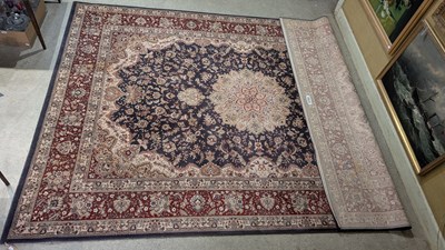 Lot 1001 - A machine made blue ground Persian style rug,...