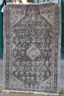 Lot 1017 - A small Persian rug, worked in blue, black and...