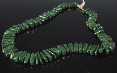 Lot 306H - A yellow metal and green stone graduated...