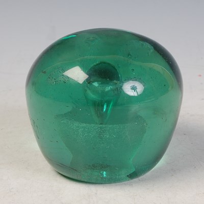 Lot 14 - A green glass dump weight with internal flower...