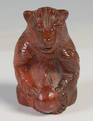 Lot 34 - A carved red stone figure of a bear, modelled...