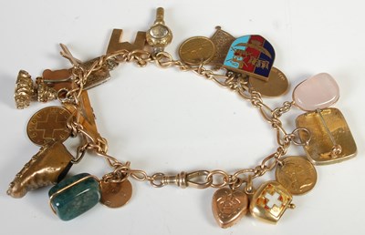 Lot 216 - A 9ct gold charm bracelet suspending twenty...