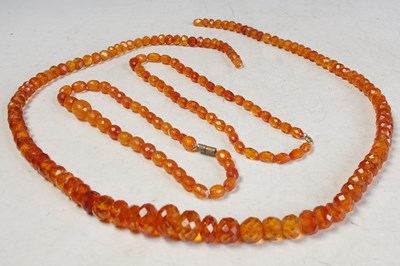 Lot 187 - Three faceted amber type bead necklaces, gross...