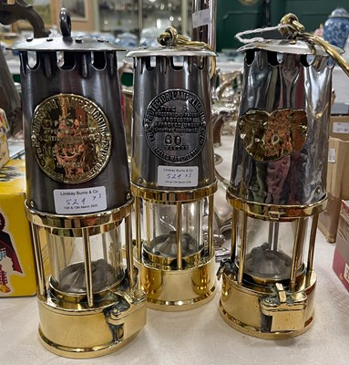 Lot 529 - Three brass miners lamps, two by The Protector...