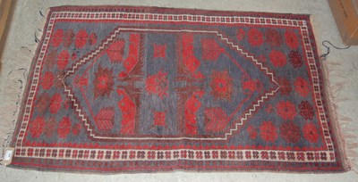 Lot 806 - A madder ground Kilim rug decorated with two...