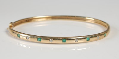 Lot 586 - A 9ct gold, emerald and diamond nine stone...
