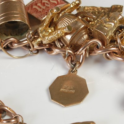 Lot 635 - A 9ct gold charm bracelet suspending twenty...