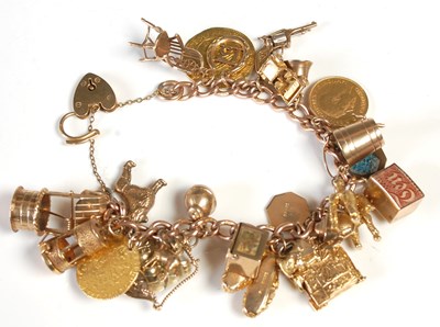 Lot 635 - A 9ct gold charm bracelet suspending twenty...