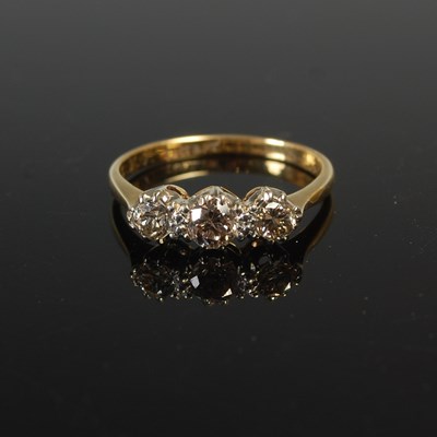 Lot 613 - A yellow and white metal three stone diamond...
