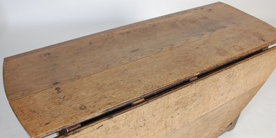 Lot 13 - An antique oak gate-leg dining table, the oval...