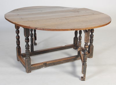 Lot 13 - An antique oak gate-leg dining table, the oval...
