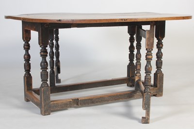 Lot 13 - An antique oak gate-leg dining table, the oval...