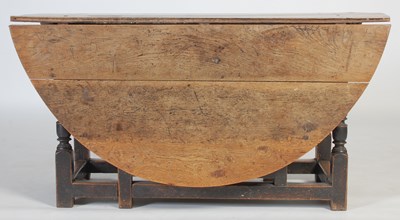 Lot 13 - An antique oak gate-leg dining table, the oval...