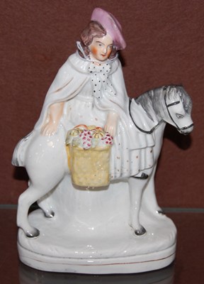 Lot 11 - A 19th century Staffordshire figure of lady on...