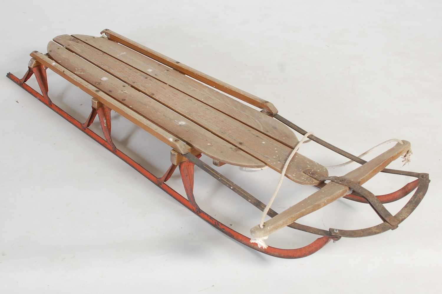 Lot 235 - A vintage wood and metal sledge, 134cm long.