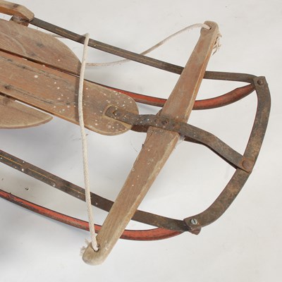 Lot 235 - A vintage wood and metal sledge, 134cm long.