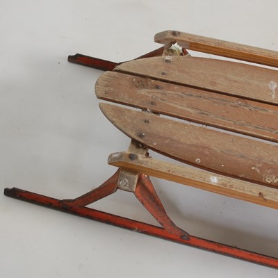 Lot 235 - A vintage wood and metal sledge, 134cm long.